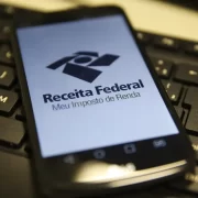 Um telefone celular com a página de entrada do site da Receita Federal, responsável pelo Imposto de Renda