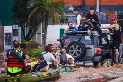 Pessoas fazendo salvamento em meio a uma enchente