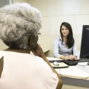 Uma idosa negra faz entrevista para trabalho, com uma jovem branca.