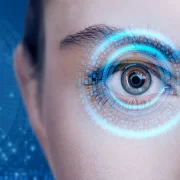 Um olho feminino com uma ilustração de laser à frente. Autora fala da sua cirurgia nos olhos, que lhe tirou os óculos