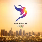 foto aérea da cidade de los angeles alaranjada pelo por do sol, com uma marca dos jogos olímpicos da cidade em 2028