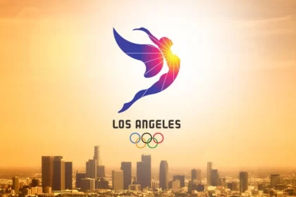 foto aérea da cidade de los angeles alaranjada pelo por do sol, com uma marca dos jogos olímpicos da cidade em 2028