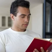 Homem negro, sentado, lendo um livro. Autor fala em diversidade.