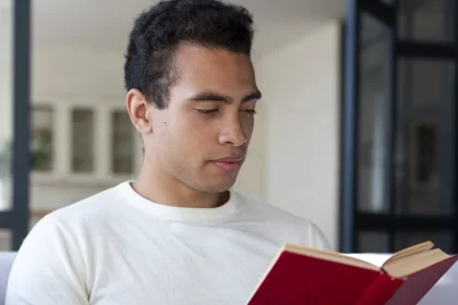 Homem negro, sentado, lendo um livro. Autor fala em diversidade.