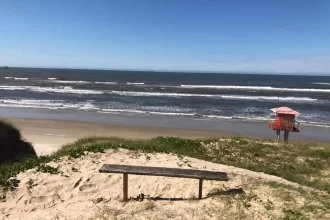 Foto de uma beira-mar com ondas ao fundo