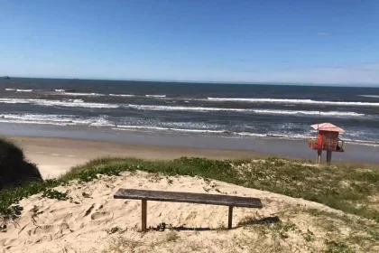 Foto de uma beira-mar com ondas ao fundo