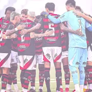 Jogadores do flamengo se abraçam no centro do campo. O time é o maior representante dos rubro-negros do país.