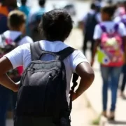 Foto de crianças de costas saindo da escola. Autora fala em abuso e violência contra crianças.