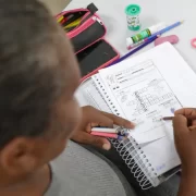 Uma mulher escreve num caderno. Autora discute conceito de inteligência